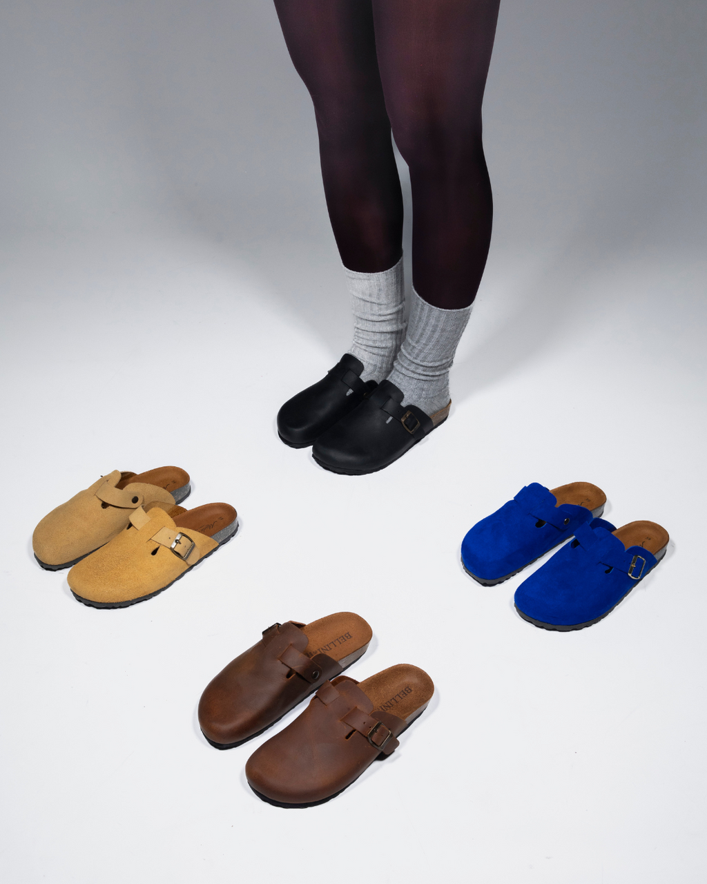 Modella con mules Bellini neri in pelle indossati e mules blu e gialli in suede e marroni in pelle affiancati durante lo shooting